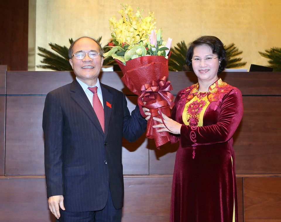  Tân Chủ tịch Quốc hội Nguyễn Thị Kim Ngân, thay mặt Ủy ban Thường vụ Quốc hội tặng hoa chúc mừng nguyên Chủ tịch Quốc hội Nguyễn Sinh Hùng. (Ảnh: Nhan Sáng/TTXVN)