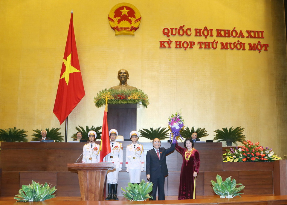 Nguyên Chủ tịch Quốc hội Nguyễn Sinh Hùng tặng hoa chúc mừng Tân Chủ tịch Quốc hội Nguyễn Thị Kim Ngân. (Ảnh: Nhan Sáng/TTXVN)