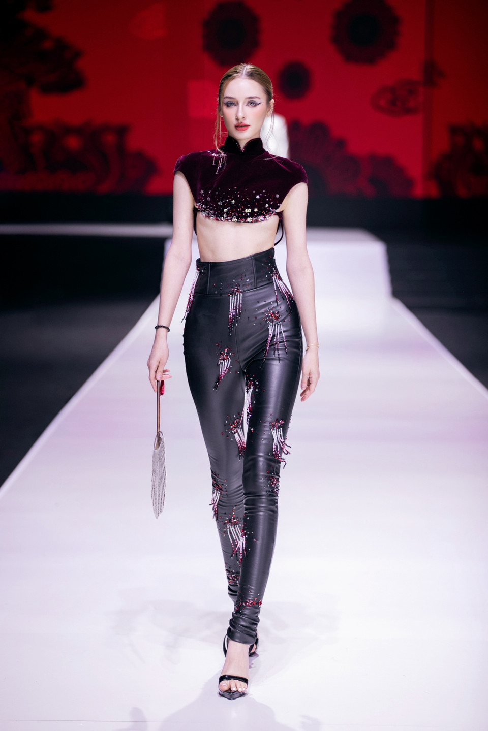 Màu sắc của từng thiết kế cũng dần thay đổi, chuyển biến từ màu sắc tươi sáng, trong trắng đến các gam màu đậm, mạnh mẽ như đen, đỏ rượu, bạc ánh kim… (Ảnh: PV/Vietnam+)