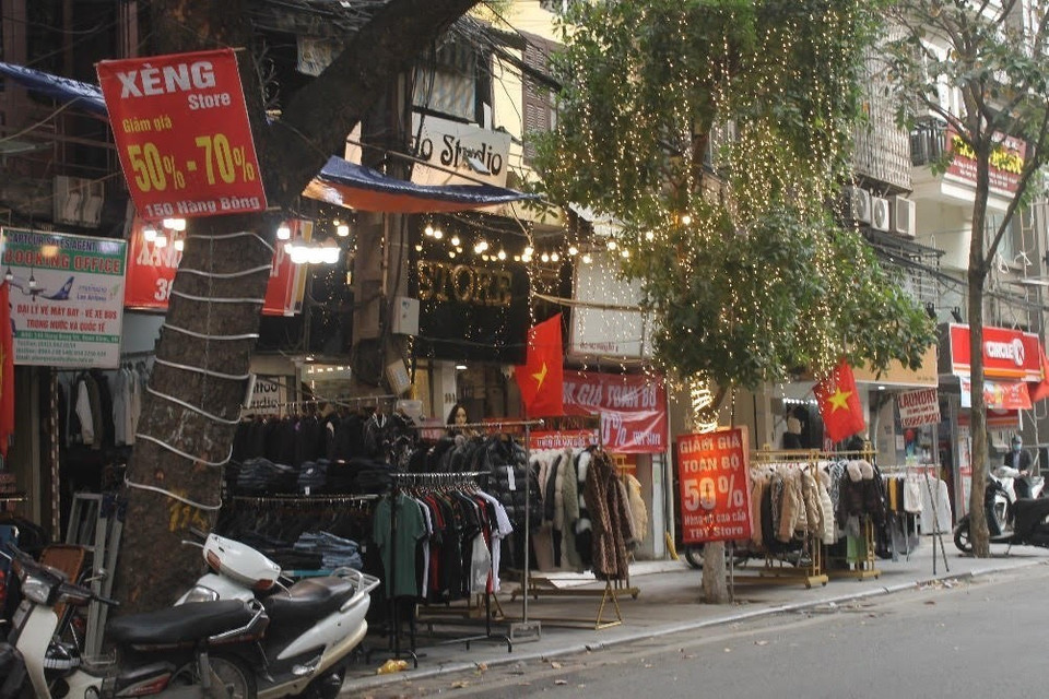 Các cửa hàng quần áo cố gắng giảm giá 'sập sàn' để thu hồi vốn trước khi đóng cửa nghỉ Tết. (Ảnh: Minh Nghĩa/TTXVN)