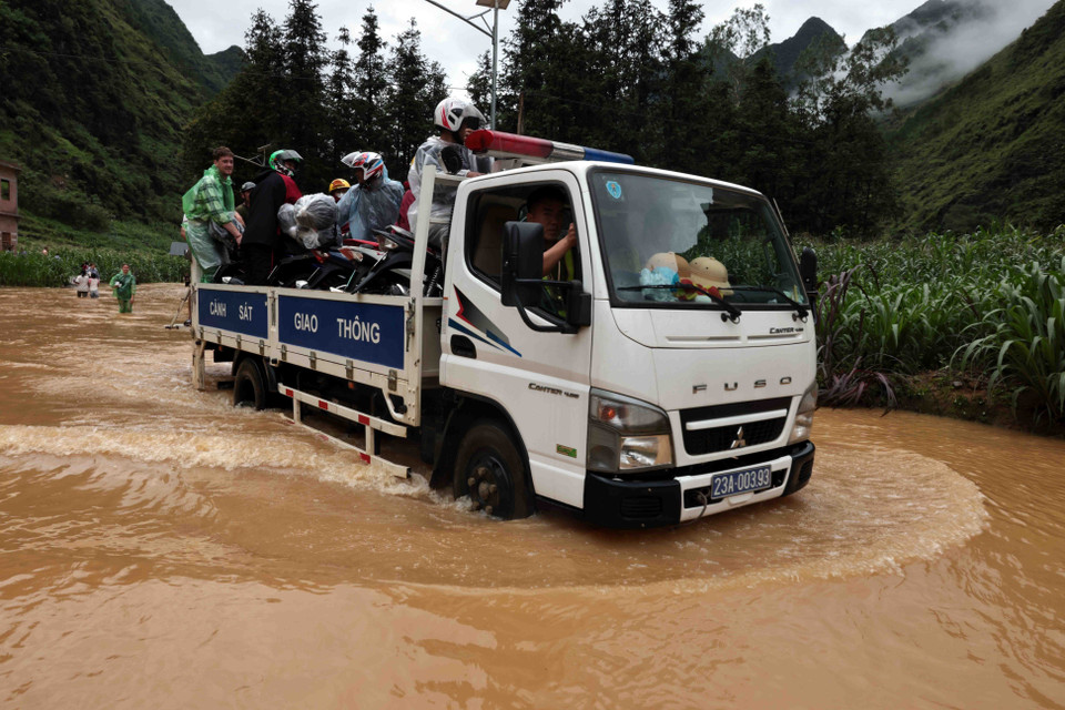 Lực lượng chức năng vận chuyển người và phương tiện do nước ngập sâu ở xã Pả Vi, huyện Mèo Vạc. (Ảnh: Trần Việt/TTXVN)