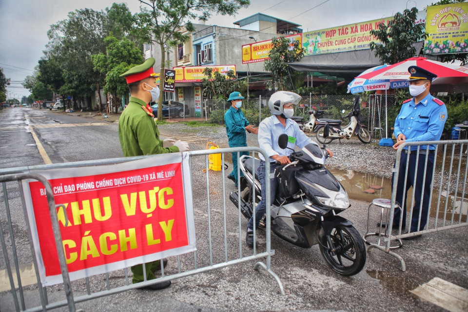 Phương tiện và người có trách nhiệm ra-vào thôn Hạ Lôi đều được phun khử khuẩn tại các chốt kiểm soát cách ly. (Ảnh: Danh Lam/TTXVN)