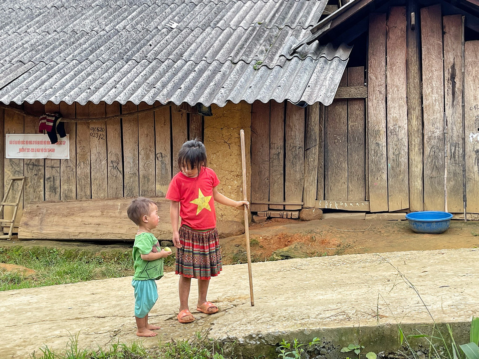 Hai chị em dắt tay nhau đi 'thị sát' đường bản. (Ảnh: Mai Mai/Vietnam+)