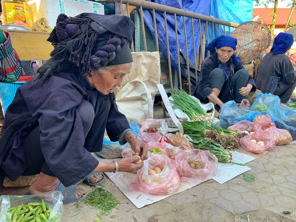 Đồng bào dân tộc vùng cao giờ cũng có phong cách bán hàng 'văn minh' như người miền xuôi, sẵn sàng làm sạch hay sơ chế sản phẩm trước khi bán cho khách. (Ảnh: Mai Mai/Vietnam+)