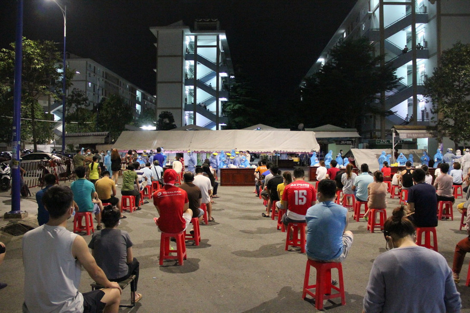 Người dân ngồi chờ đến lượt, đảm bảo giãn cách. (Ảnh: Văn Hướng/TTXVN)