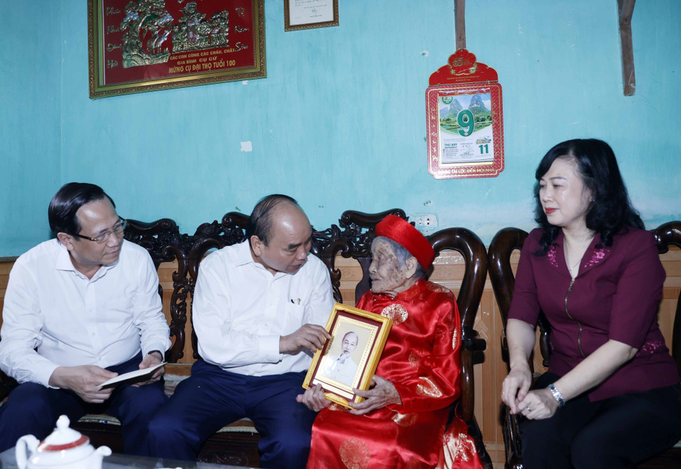 Chủ tịch nước Nguyễn Xuân Phúc thăm hỏi và tặng quà cho Mẹ Việt Nam Anh hùng Nguyễn Thị Ngần. (Ảnh: Thống Nhất/TTXVN)