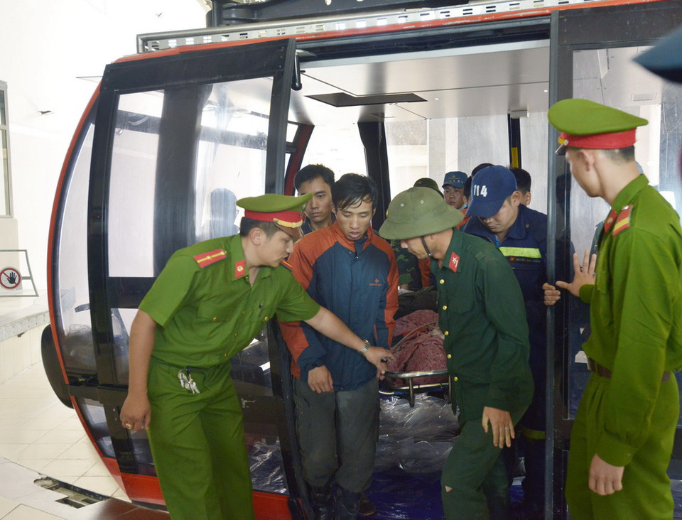 Lực lượng cứu hộ di chuyển thi thể nạn nhân bằng cáp treo. (Ảnh: Hương Thu/TTXVN) 