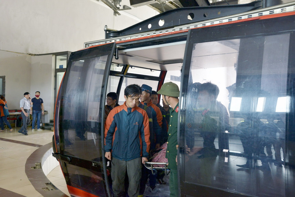 Lực lượng cứu hộ di chuyển thi thể nạn nhân bằng cáp treo. (Ảnh: Hương Thu/TTXVN) 