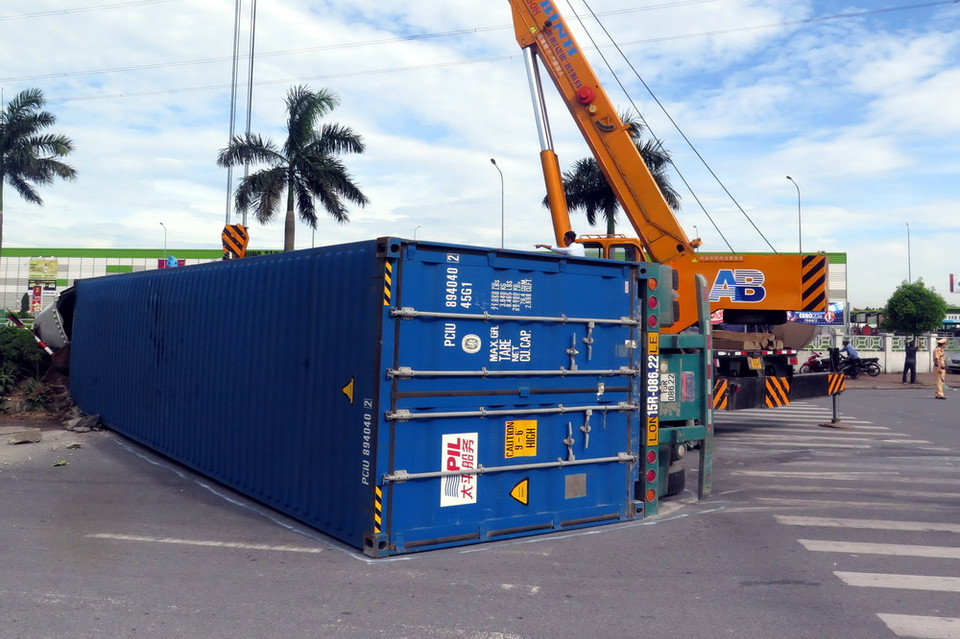Xe container mang biển kiểm soát 15C-160.40 (rơmoóc mang biển kiểm soát 15R-086.22) bị mất lái đâm vào dải phân cách giữa hai làn đường lật ngang giữa đường. (Ảnh: Văn Đạt/TTXVN)