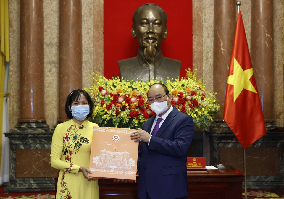 Chủ tịch nước Nguyễn Xuân Phúc tặng quà cho cán bộ y tế tiêu biểu toàn quốc. (Ảnh: Thống Nhất/TTXVN)