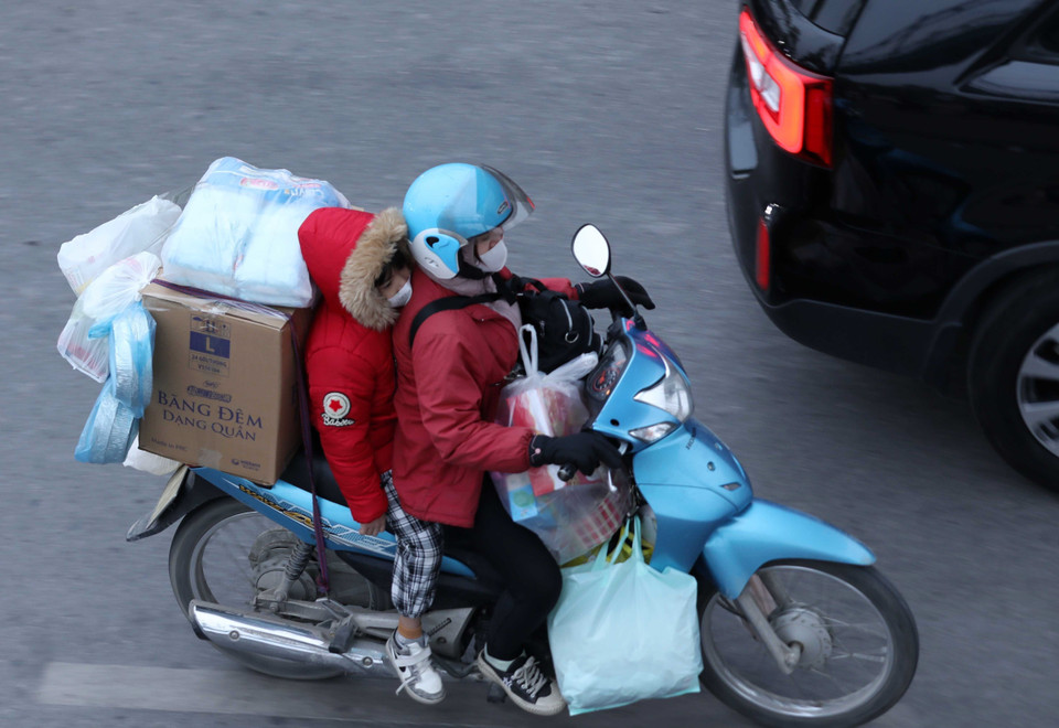 Dễ dàng bắt gặp chiếc xe máy chở cồng kềnh đồ đạc trên đường. (Ảnh: Hoàng Hiếu/TTXVN)