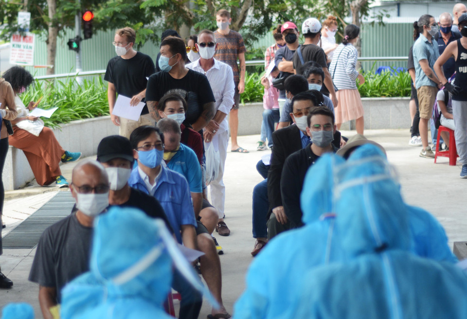 Người nước ngoài xếp hàng chờ đến lượt làm xét nghiệm. (Ảnh: Văn Dũng/TTXVN)