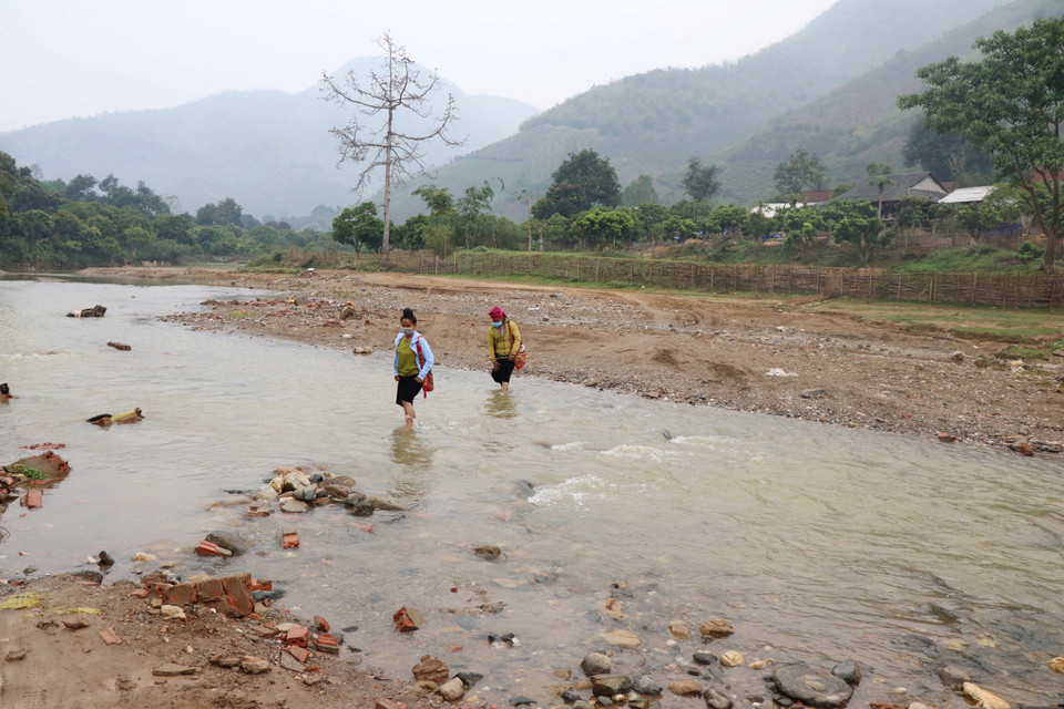 Người dân bản Đen, xã Chiềng Khương, huyện Sông Mã hàng ngày phải lội suối để đi lại. (Ảnh: Hữu Quyết/TTXVN)
