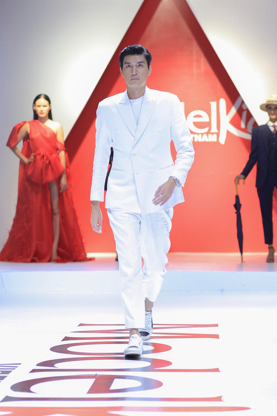 Huấn luận viên Quang Đại vẫn xây dựng hình ảnh bảnh bao, thanh lịch bằng bộ suit trắng đơn giản và thu hút mọi ánh nhìn bằng nụ cười rạng rỡ. (Ảnh: BTC)