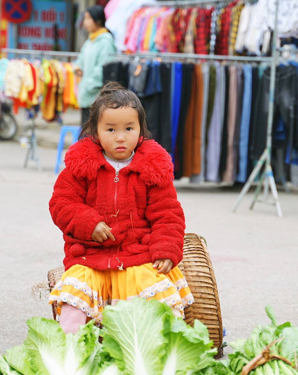 Một em bé theo mẹ đi bán hàng tại chợ phiên Mèo Vạc. (Ảnh: Khánh Hòa/TTXVN)