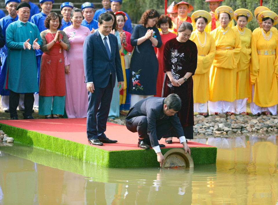 Thả cá chép tiễn ông Công, ông Táo theo nghi thức truyền thống. (Ảnh: Thanh Tùng/TTXVN)