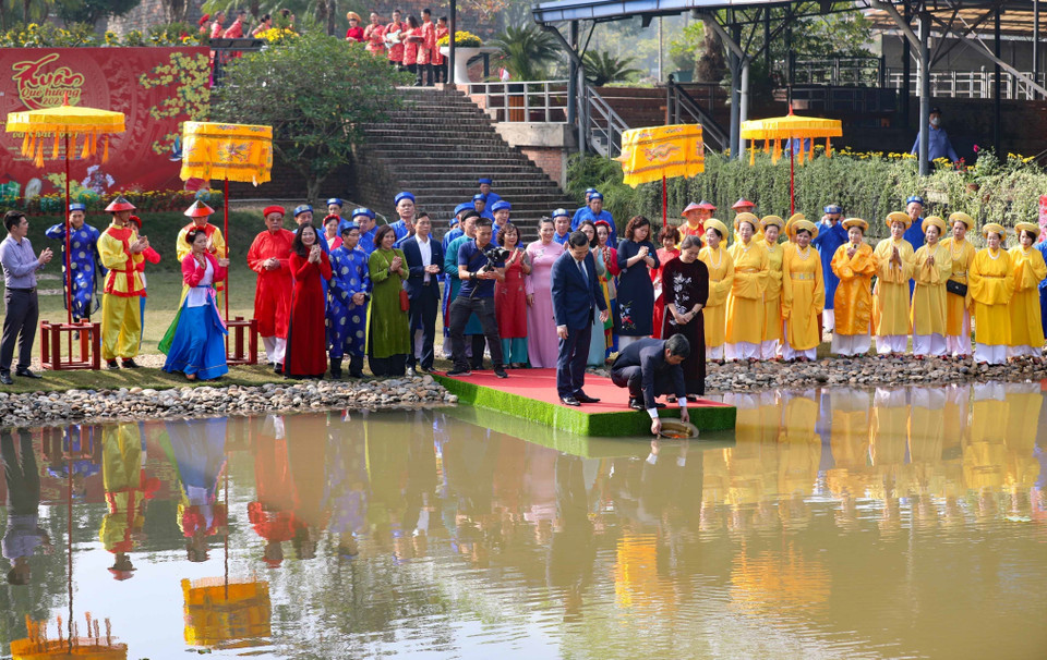 Nghi thức thả cá chép tiễn ông Công, ông Táo tại Khu di tích Hoàng thành Thăng Long. (Ảnh: Thanh Tùng/TTXVN)