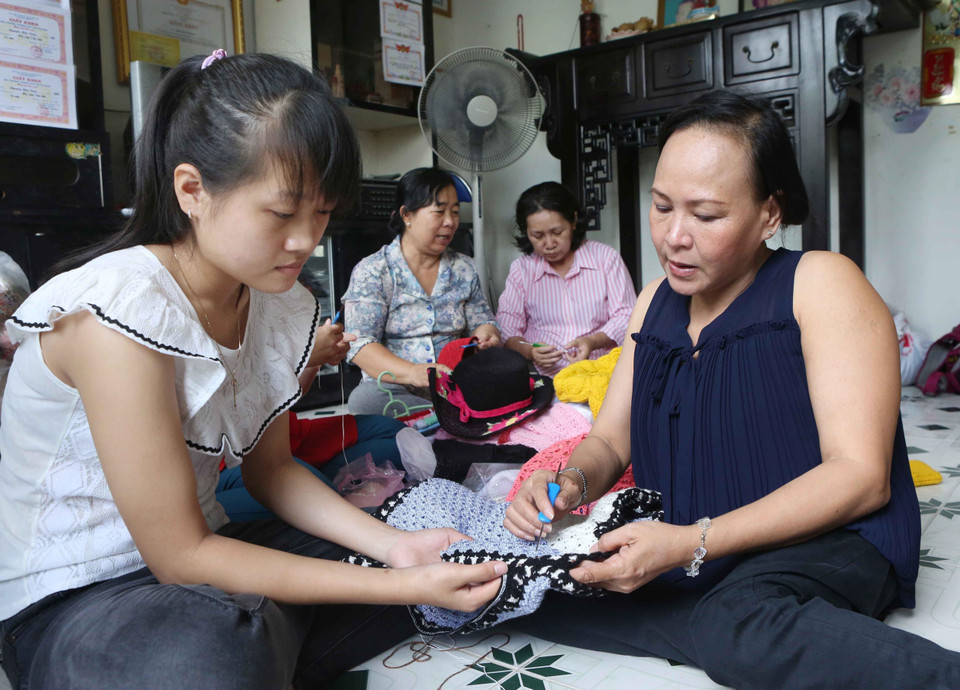 Chị Đinh Thị Tuyết Đào (phải), chủ cơ sở đan len Phước Đào, 174/12 Lê Văn Lương, phường Tân Hưng, quận 7 (Thành phố Hồ Chí Minh) là người bị bại liệt từ nhỏ. Năm 2006, chị được Hội Liên hiệp Phụ nữ phường giúp vay vốn xóa đói giảm nghèo, thành lập cơ sở đan móc len thủ công, tạo việc làm cho hơn 40 chị em khu phố có cùng hoàn cảnh. (Ảnh: Phương Hoa/TTXVN)