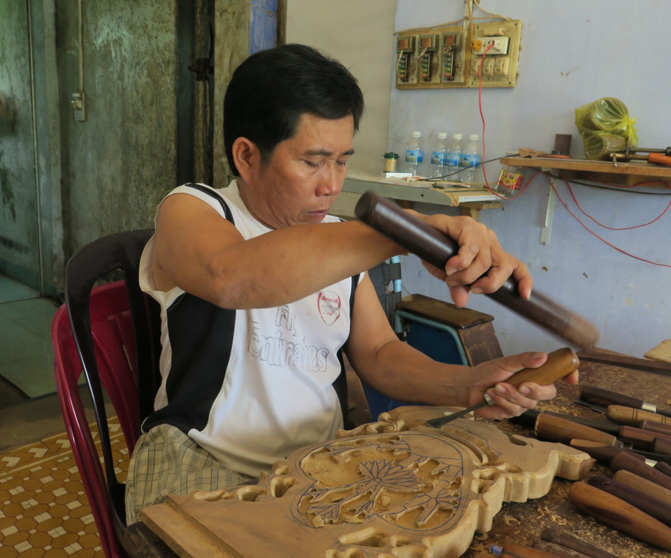 Hội viên Lê Viết Luận (Hội Người khuyết tật huyện Diên Khánh, tỉnh Khánh Hòa) là người thầy truyền nghề chạm khắc cho các hội viên khuyết tật khác. (Ảnh: Phan Sáu/TTXVN)