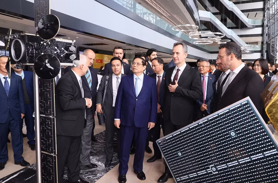 Thủ tướng Phạm Minh Chính xem mô hình sản phẩm của Tập đoàn Công nghiệp Hàng không Vũ trụ Thổ Nhĩ Kỳ. (Ảnh: Dương Giang/TTXVN)