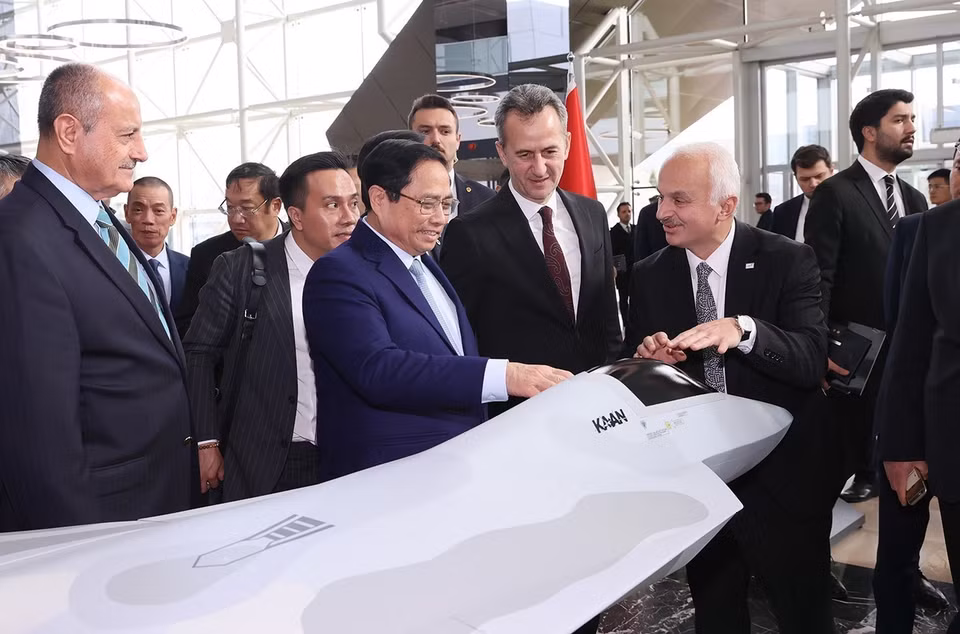 Thủ tướng Phạm Minh Chính xem mô hình sản phẩm của Tập đoàn Công nghiệp Hàng không Vũ trụ Thổ Nhĩ Kỳ. (Ảnh: Dương Giang/TTXVN)