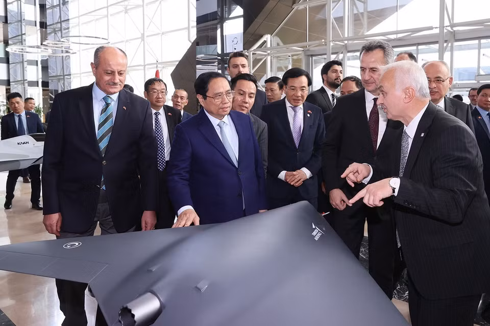Thủ tướng Phạm Minh Chính xem mô hình sản phẩm của Tập đoàn Công nghiệp Hàng không Vũ trụ Thổ Nhĩ Kỳ. (Ảnh: Dương Giang/TTXVN)