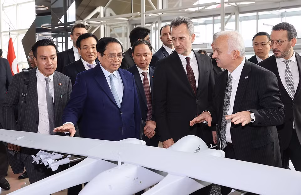 Thủ tướng Phạm Minh Chính xem mô hình sản phẩm của Tập đoàn Công nghiệp Hàng không Vũ trụ Thổ Nhĩ Kỳ. (Ảnh: Dương Giang/TTXVN)