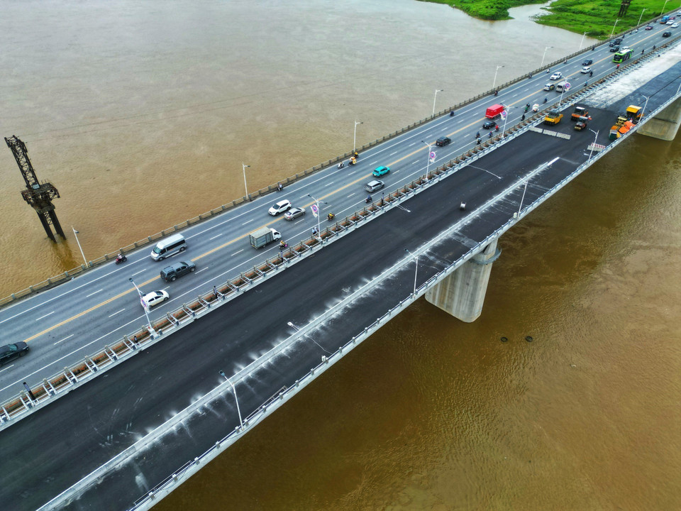 Các đơn vị thi công đang khẩn trương thảm nhựa mặt cầu. (Ảnh: Tuấn Anh/TTXVN)