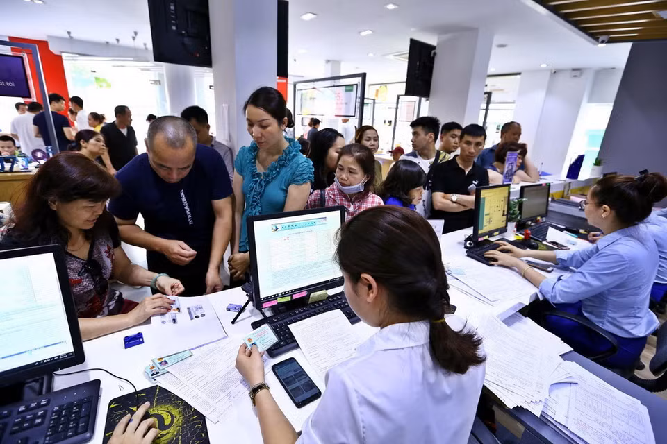 Khách hàng đến đăng ký thông tin thêu bao di động tại điểm giao dịch của Mobifone khu vực phố Xã Đàn. (Ảnh: Minh Quyết/TTXVN)