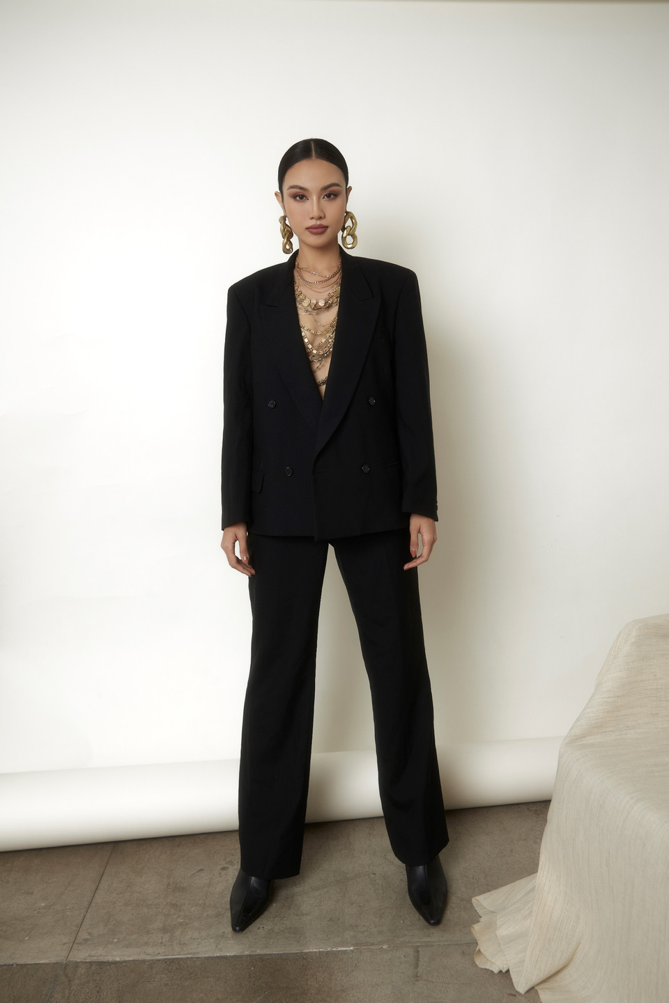 Loạt phụ kiện ánh kim bắt mắt vừa làm nổi bật bộ trang sức, vừa tạo nên điểm nhấn thú vị cho set đồ màu đen quyền lực. Đôi bông tai kích cỡ lớn không khiến set đồ rườm rà mà tạo điểm cân bằng và làm tổng thể bộ trang phục hài hòa, hút mắt hơn. (Ảnh: CTV/Vietnam+)