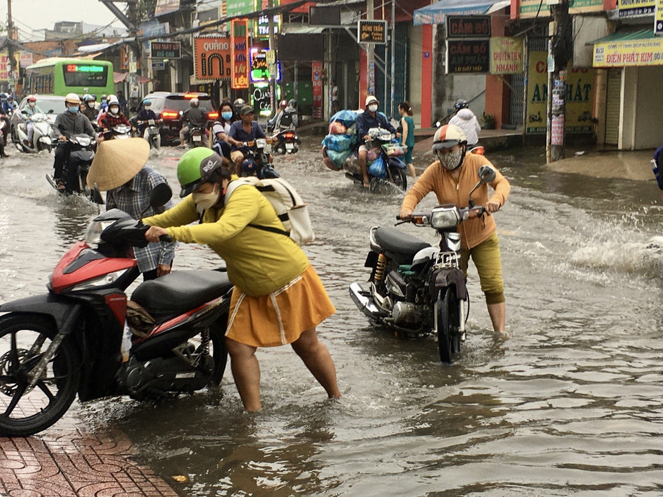 Nhiều phương tiện bị chết máy phải dắt bộ trên Quốc lộ 30, huyện Bình Chánh. (Ảnh: Thanh Vũ/TTXVN)