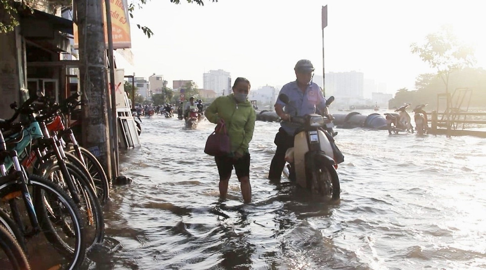 Người dân vất vả di chuyển trên đường Trần Xuân Soạn, quận 7.(Ảnh: Thanh Vũ/TTXVN)