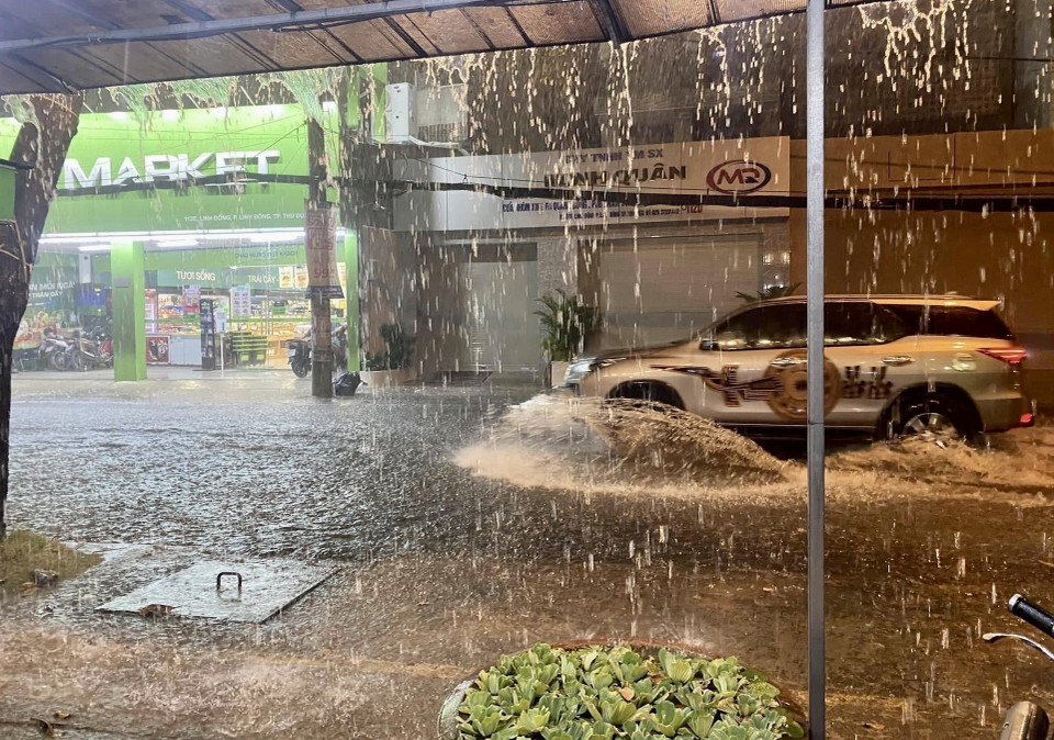 Nước ngập gần nửa bánh xe hơi trên đường Linh Đông, thành phố Thủ Đức. (Ảnh: Hồng Giang/TTXVN)