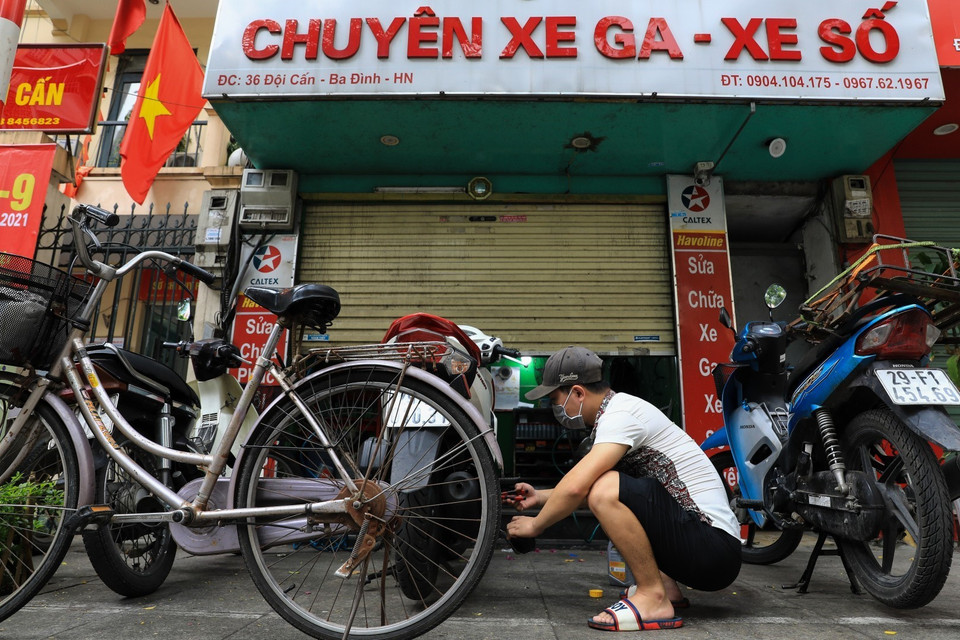 Đúng 13h, cửa hàng sửa chữa xe máy trên phố Đội Cấn, quận Ba Đình mở cửa trở lại phục vụ khách hàng. (Ảnh: Thành Đạt/TTXVN)
