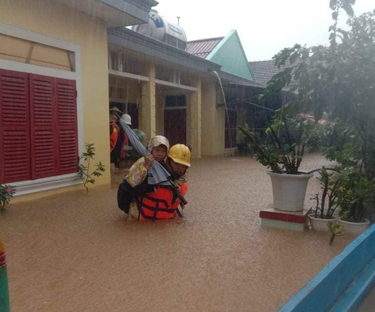 Lực lượng điện lực Quảng Bình kiểm tra an toàn điện và ứng cứu bà con vùng lũ. (Ảnh: Đức Thọ/TTXVN)