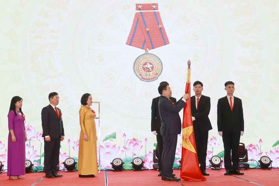 Chủ tịch Quốc hội Vương Đình Huệ gắn Huân chương Lao động hạng Nhì lên cờ truyền thống của Ban Công tác đại biểu. (Ảnh: Doãn Tấn/TTXVN)