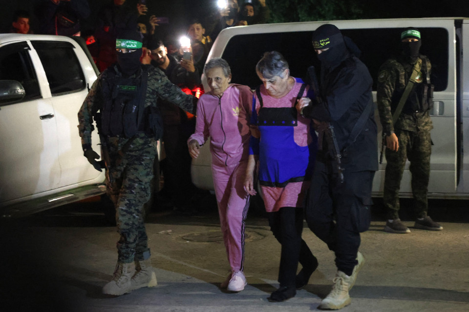 Các đợt trao đổi con tin giữa Israel và phong trào Hamas tại Dải Gaza đã diễn ra 7 ngày liên tiếp, tương ứng với thời gian của lệnh ngừng bắn. Thỏa thuận ngừng bắn sẽ hết hạn vào lúc 5h00 ngày 1/12 giờ GMT. Ảnh: Các tay súng Hamas bàn giao nhóm con tin người Israel cho Ủy ban Chữ Thập đỏ quốc tế tại Dải Gaza ngày 28/11/2023.(AFP/TTXVN)