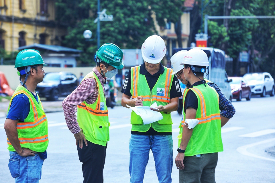Cán bộ Sở Giao thông Vận tải Hà Nội trao đổi thông tin về tổ chức phân làn trên đoạn phố Trần Hưng Đạo. (Ảnh: Tuấn Anh/TTXVN)