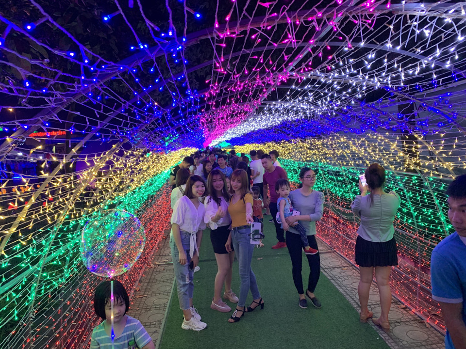 Người dân tham quan, chụp ảnh với các mô hình ánh sáng nhiều màu sắc. (Ảnh: Hiền Anh/TTXVN)