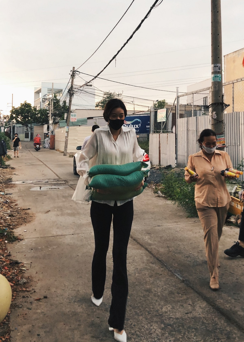 Cô và mẹ trực tiếp cùng các cán bộ đi đến các hộ dân ở khu vực này để trao quà. (Ảnh: CTV/Vietnam+)