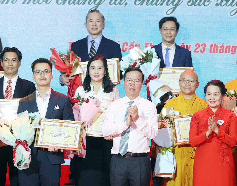 Chủ tịch nước Võ Văn Thưởng, Chủ tịch danh dự Hội Chữ thập Đỏ Việt Nam và bà Bùi Thị Hòa, Chủ tịch Hội Chữ thập Đỏ Việt Nam tặng hoa và trao bảng Ghi nhận tấm lòng vàng nhân đạo. (Ảnh: Thống Nhất/TTXVN)