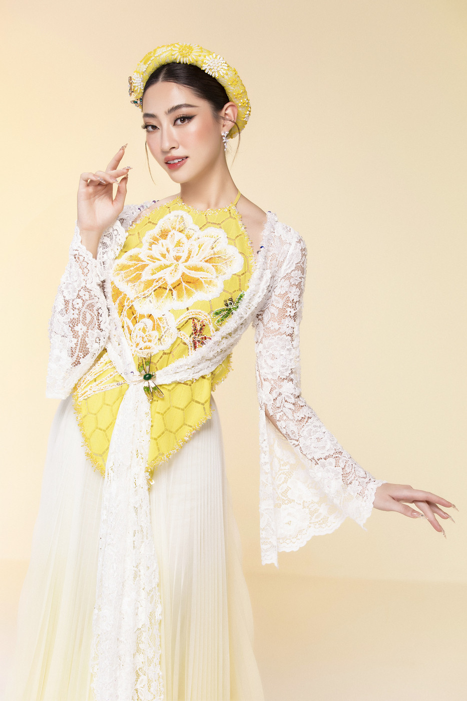 Diện bộ trang phục tứ thân, tôn lên vóc dáng mảnh mai và những đường nét dịu dàng. Thiết kế kết hợp giữa hai tông màu trắng và vàng cùng điểm nhấn bông hoa nở rộ khiến nàng hậu thêm phần duyên dáng. (Ảnh: CTV/Vietnam+)