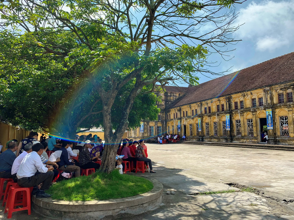 Rất đông giáo dân không đủ chỗ ngồi trong nhà thờ Chính tòa Bùi Chu phải ngồi bên ngoài. (Ảnh: Xuân Mai/Vietnam+)