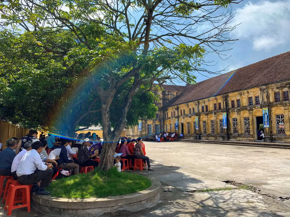 Rất đông giáo dân không đủ chỗ ngồi trong nhà thờ Chính tòa Bùi Chu phải ngồi bên ngoài. (Ảnh: Xuân Mai/Vietnam+)