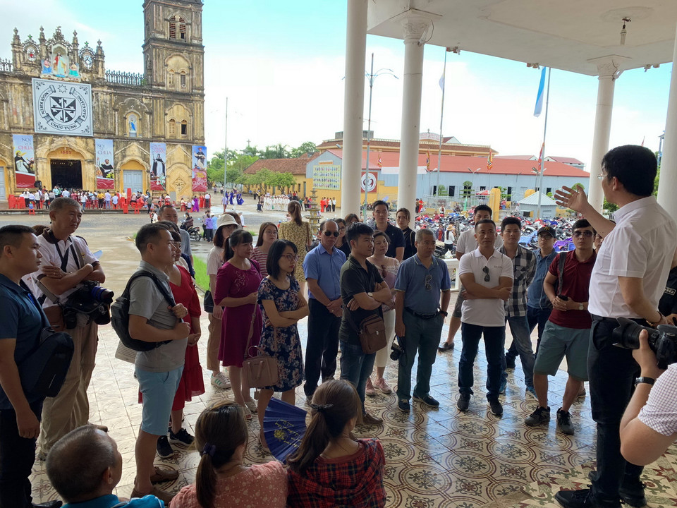 Du khách nghe giới thiệu về nhà thờ cũng như ngày lễ thánh nữ Monica và thánh nữ Anê Lê Thị Thành. (Ảnh: Xuân Mai/Vietnam+)