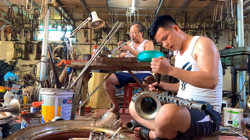 Hàng ngày, những chiếc kèn đồng có nhiều chi tiết phức tạp vẫn được đôi bàn tay tài hoa của người thợ làng Phạm Pháo làm ra. Hầu hết các công đoạn đều được làm thủ công, ngay cả đánh bóng và tạo âm. Các công đoạn chế tác tưởng chừng thô sơ nhưng những chiếc kèn Tây ra đời từ đây đều được đánh giá cao về chất lượng. (Ảnh: Xuân Mai/Vietnam+)