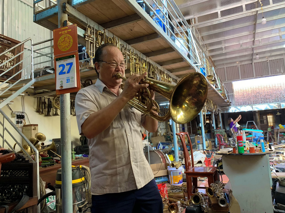 Ông Nguyễn Văn Cường là truyền nhân thứ 2 trong gia đình làm nghề kèn đồng có tiếng ở làng. Ông Cường cho biết, những ống đồng được cán phẳng, gò tay thành một chiếc kèn và chỉ sử dụng máy uốn tự chế, máy tiện cho các chi tiết và công đoạn khó. Tới nay, thế hệ tứ tư trong gia đình ông Cường vẫn tiếp tục nối nghiệp cha ông. (Ảnh: Xuân Mai/Vietnam+)