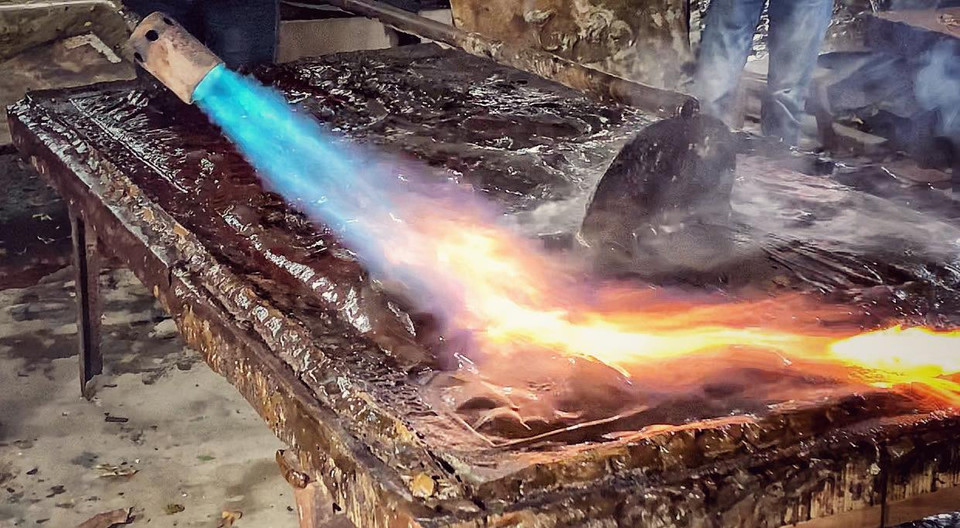 Để tạo ra một sản phẩm hoàn chỉnh phải trải qua nhiều công đoạn. Đầu tiên phải cắt đồng, làm khuôn, thúc tay rồi chạm trổ, làm bóng trước khi mài, mạ đồng. (Ảnh: M.Mai/Vietnam+)