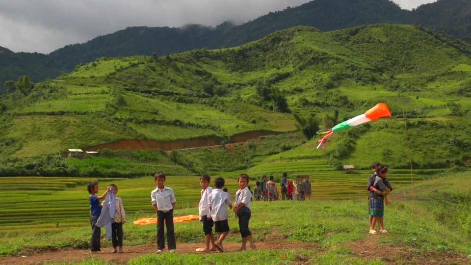 Đội nắng, đội gió và có lúc đội cả mưa nhưng vẫn háo hức chờ một cánh diều bổ bộ. (Ảnh: Tùng Lâm/Vietnam+)