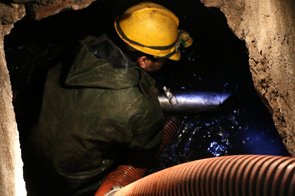 Công nhân Công ty trách nhiệm hữu hạn một thành viên Thoát nước Hà Nội vẫn phải thực hiện nhiệm vụ chuyên môn của mình. (Ảnh: TTXVN phát)